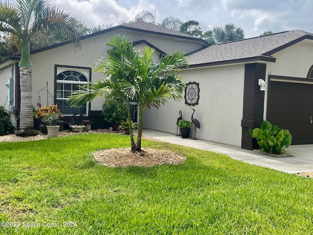 view of front of home with a front yard and a garage