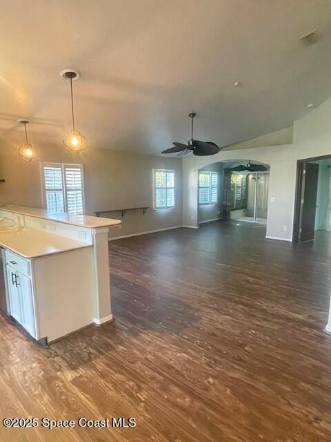 kitchen featuring a center island, lofted ceiling, ceiling fan, decorative light fixtures, and white cabinetry