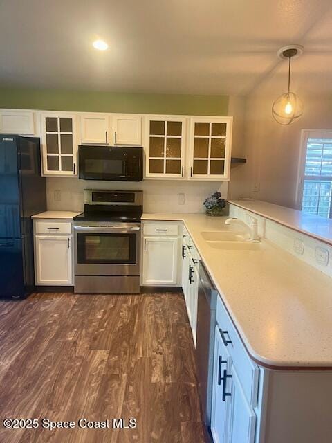 kitchen featuring white cabinetry, hanging light fixtures, and black appliances