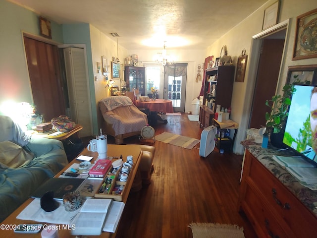 living room featuring a notable chandelier and dark hardwood / wood-style flooring