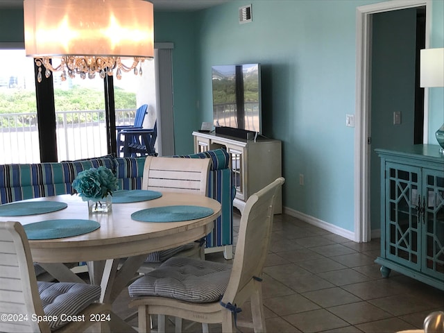 tiled dining area featuring a notable chandelier