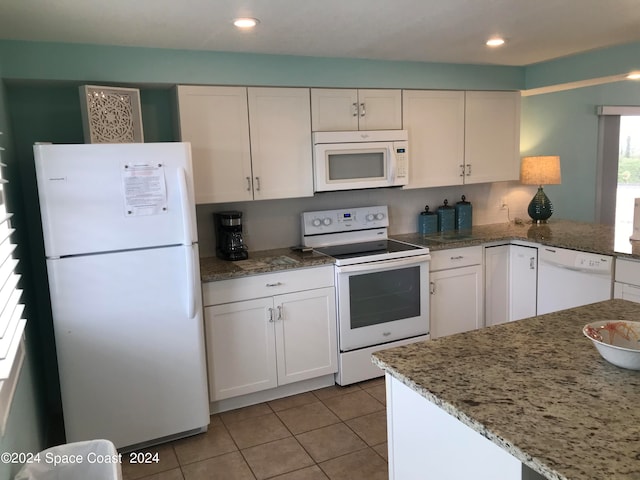 kitchen with stone counters, white appliances, white cabinetry, and light tile patterned floors