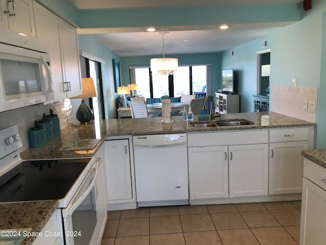 kitchen featuring white appliances, an inviting chandelier, sink, and white cabinets