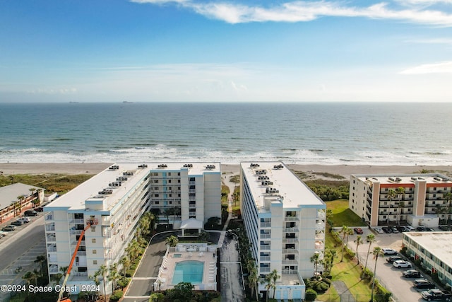 birds eye view of property featuring a beach view and a water view