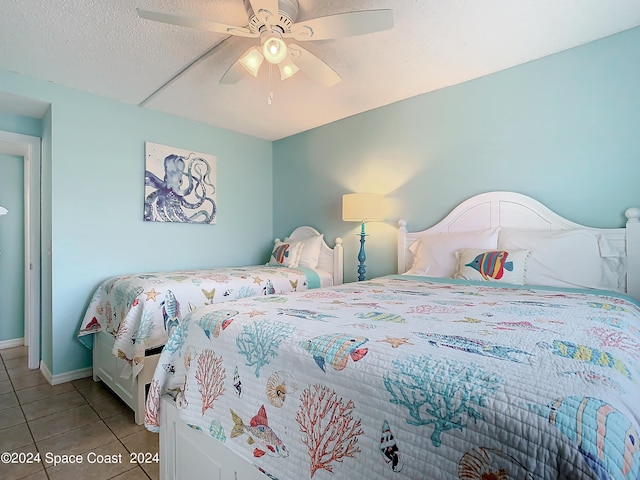 bedroom featuring a textured ceiling, light tile patterned floors, and ceiling fan