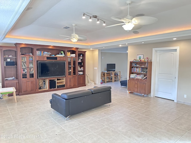 living area with light tile patterned floors, a raised ceiling, visible vents, and a ceiling fan