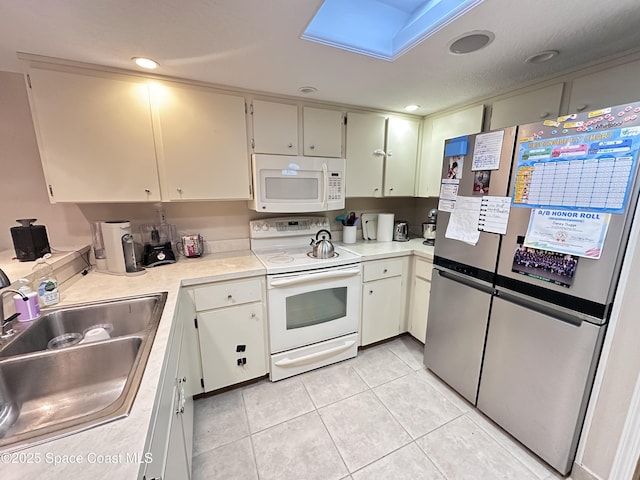 kitchen featuring white appliances, light tile patterned floors, light countertops, a sink, and recessed lighting