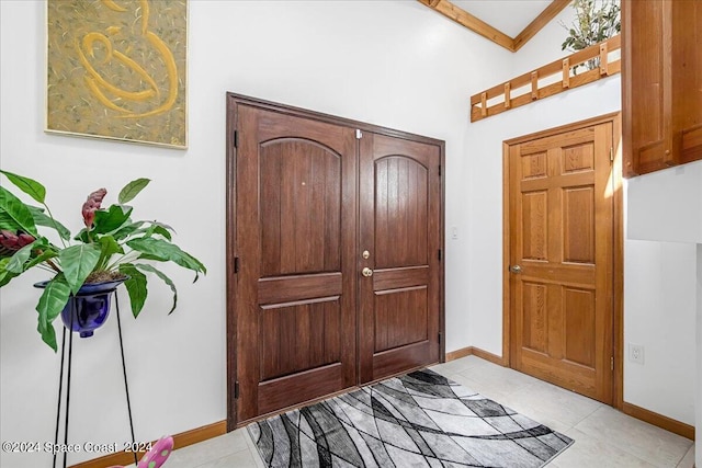 entryway with lofted ceiling and light tile patterned floors