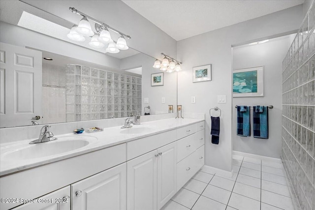 bathroom with tile patterned floors, a shower, and vanity