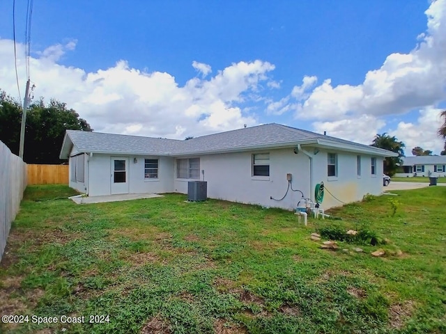 back of property with a patio, central AC, and a yard