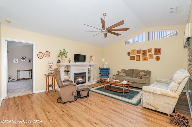 living room with ceiling fan, vaulted ceiling, and light hardwood / wood-style flooring