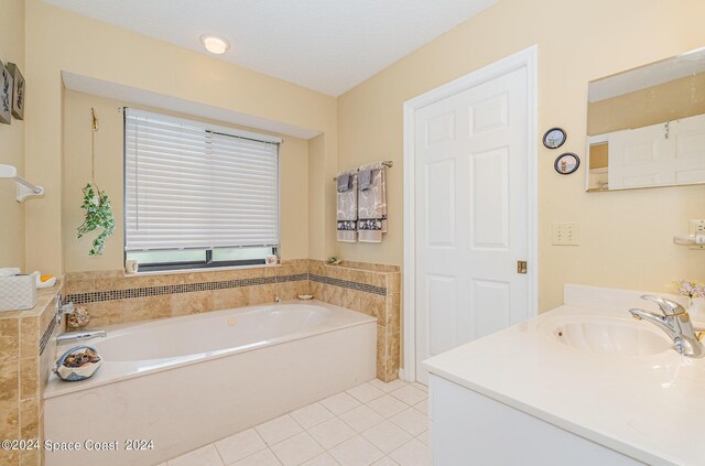 bathroom featuring vanity, a bath, tile patterned floors, and a textured ceiling