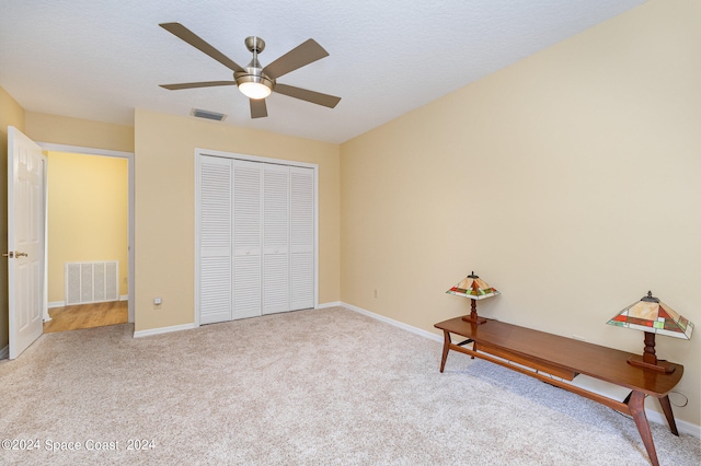 unfurnished bedroom with ceiling fan, light carpet, and a closet