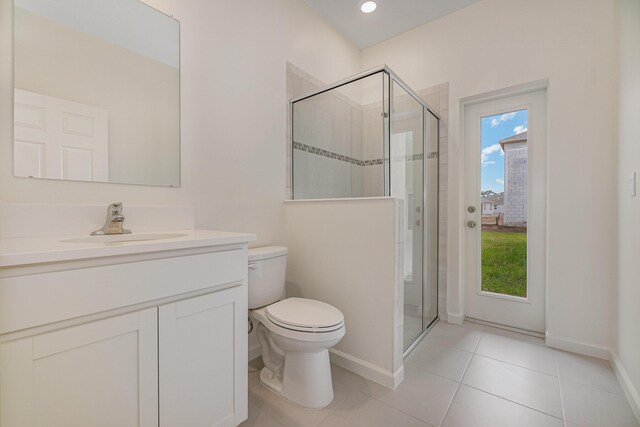 bathroom featuring tile patterned flooring, vanity, toilet, and an enclosed shower