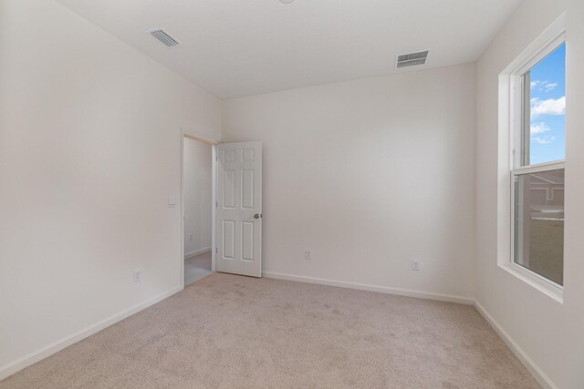 spare room featuring light colored carpet