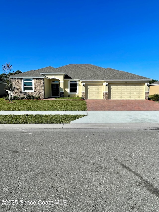 view of front of house with a front yard and a garage