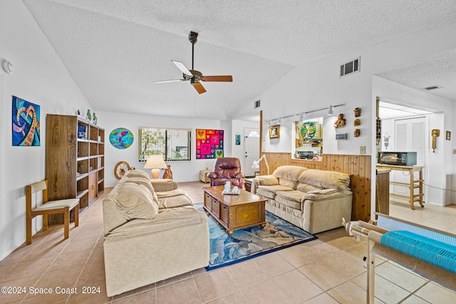 tiled living room featuring lofted ceiling, ceiling fan, and a textured ceiling