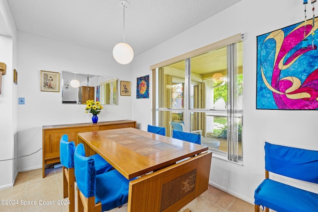 tiled dining room with a textured ceiling