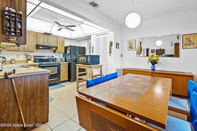 kitchen featuring light tile patterned floors, pendant lighting, black appliances, ceiling fan, and sink