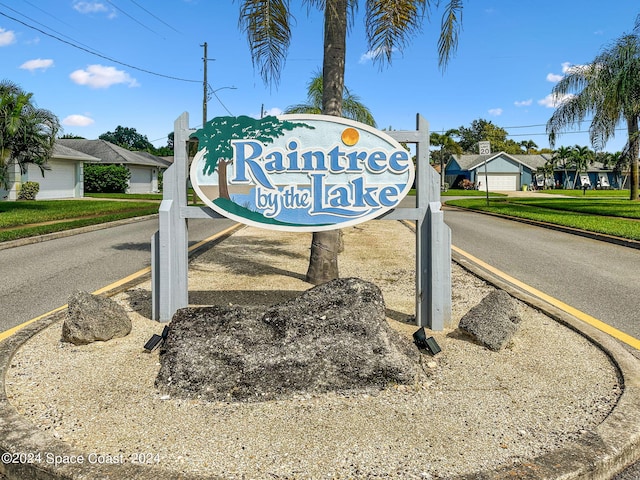 community / neighborhood sign with a garage and a lawn