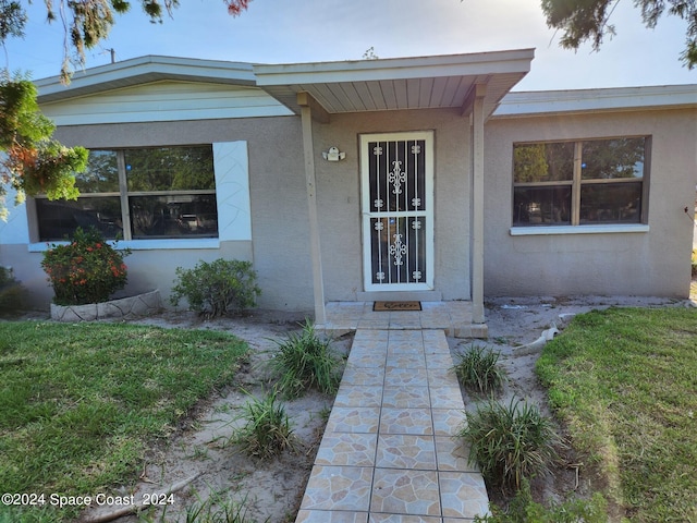 doorway to property featuring a lawn