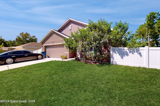 obstructed view of property with a garage and a front lawn