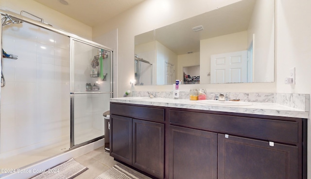 bathroom with tile patterned flooring, a shower with door, and vanity