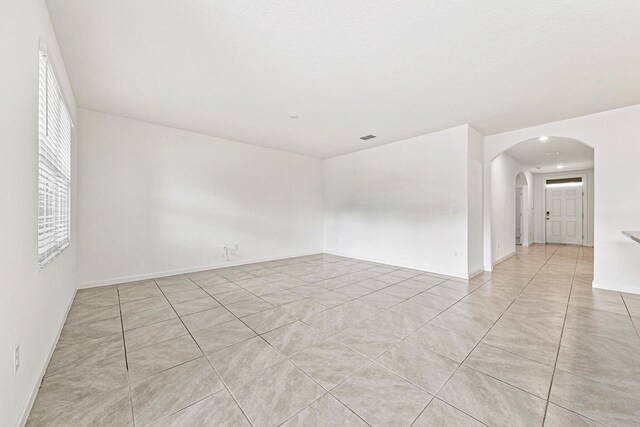 tiled spare room with a textured ceiling