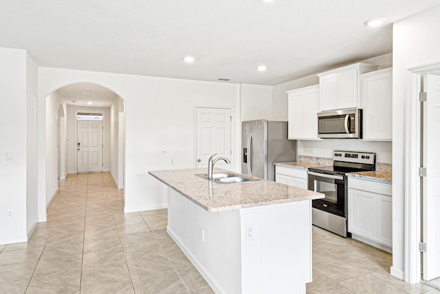 kitchen featuring white cabinets, appliances with stainless steel finishes, an island with sink, and sink