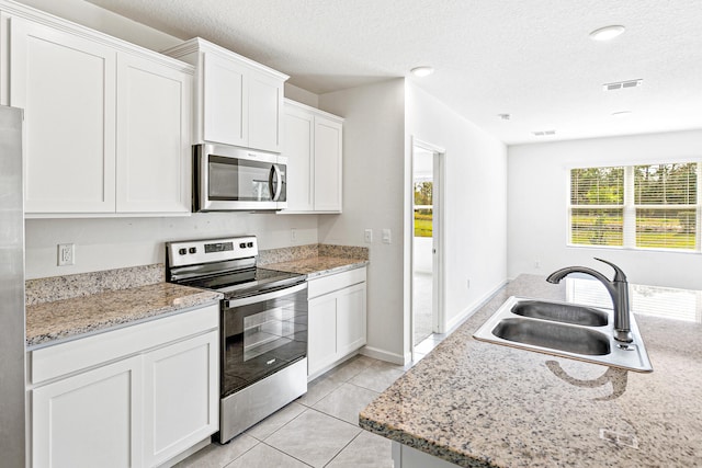 kitchen featuring white cabinets, appliances with stainless steel finishes, a textured ceiling, and sink