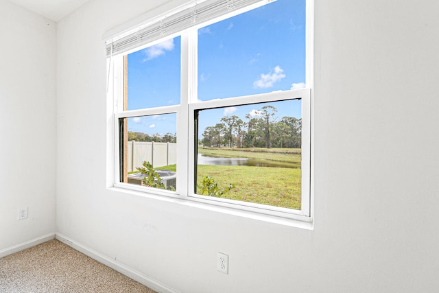 carpeted spare room with a water view