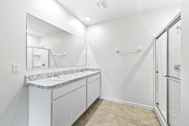 bathroom featuring a shower with door, vanity, and tile patterned floors