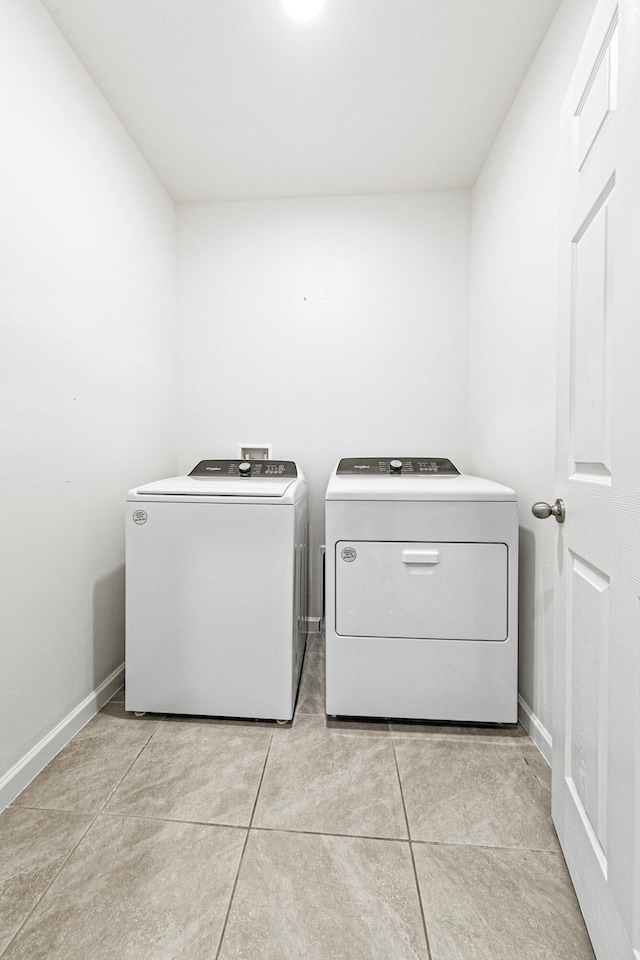 laundry room with washing machine and dryer and light tile patterned flooring