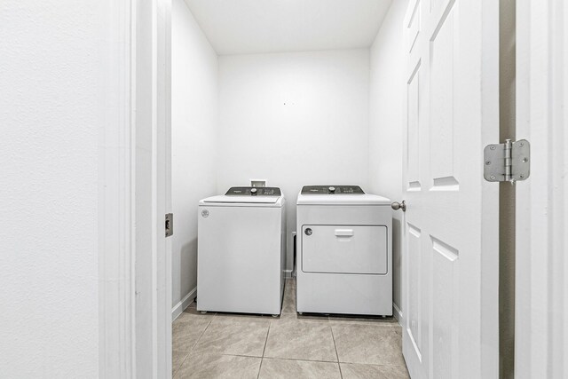 laundry room featuring light tile patterned floors and washer and clothes dryer