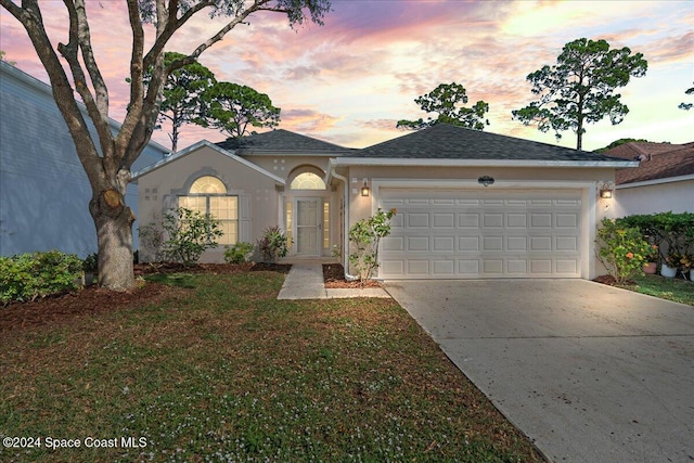 view of front of home featuring a lawn and a garage