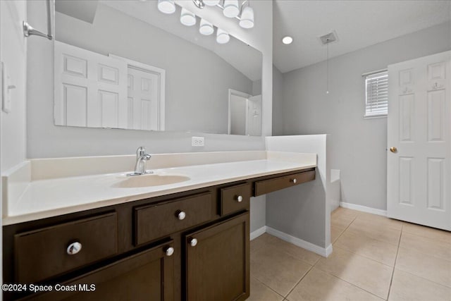 bathroom featuring a washtub, vanity, vaulted ceiling, and tile patterned flooring