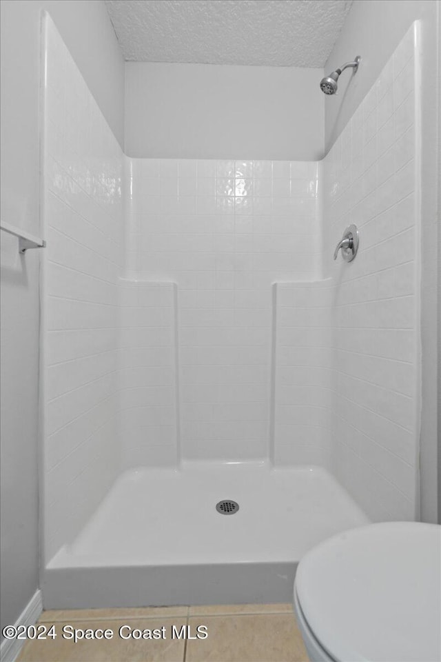 bathroom featuring toilet, a textured ceiling, and walk in shower