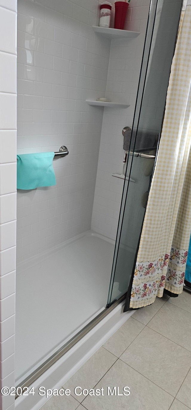 bathroom with tile patterned flooring and a shower with door