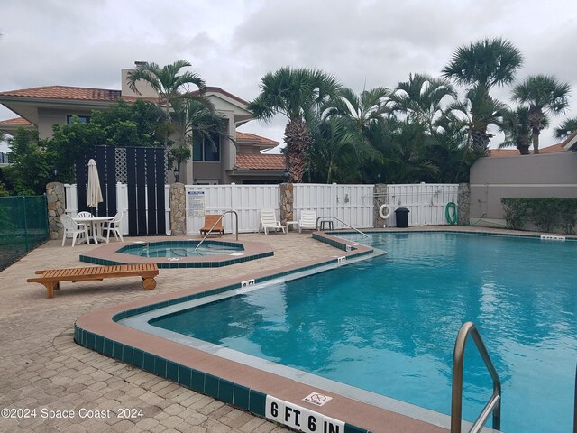 view of swimming pool with a community hot tub and a patio area