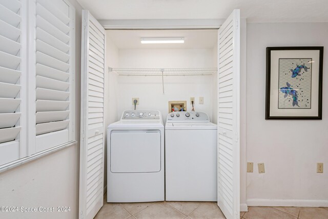 clothes washing area featuring light tile patterned floors and washing machine and dryer