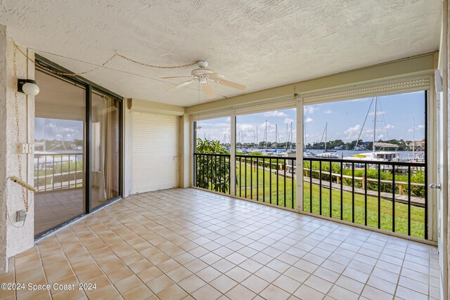 unfurnished sunroom featuring ceiling fan and a healthy amount of sunlight