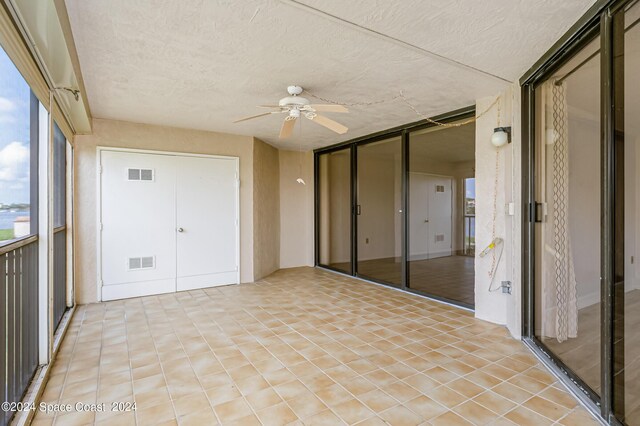 unfurnished sunroom with ceiling fan