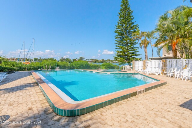 view of swimming pool with a hot tub and a patio area