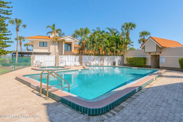 view of pool featuring a community hot tub and a patio area