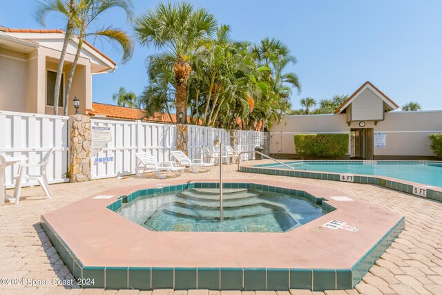 view of swimming pool featuring a hot tub