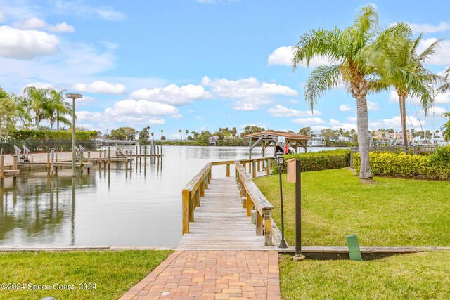 view of dock featuring a water view and a yard