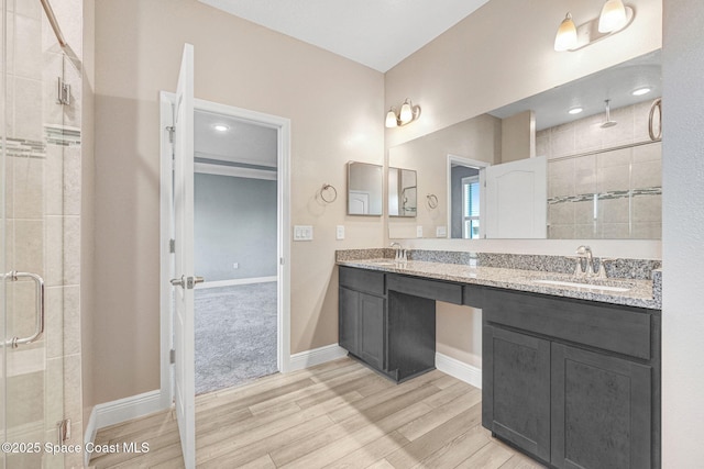 bathroom with wood-type flooring, vanity, and walk in shower