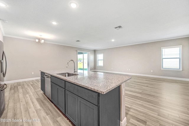 kitchen with a kitchen island with sink, sink, ornamental molding, light hardwood / wood-style floors, and stainless steel appliances