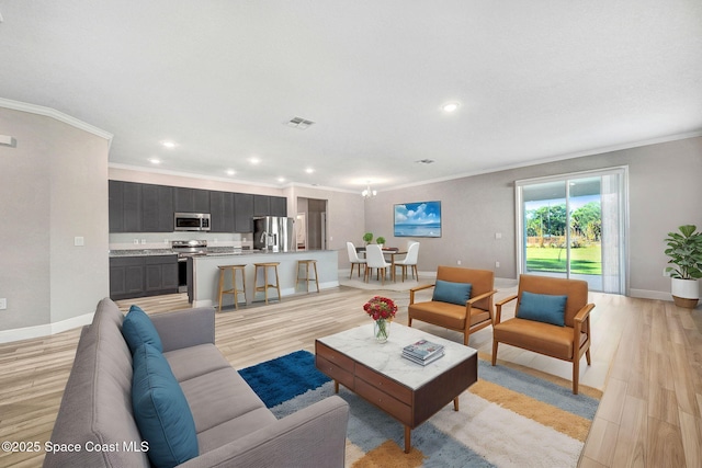 living room with ornamental molding and light hardwood / wood-style flooring