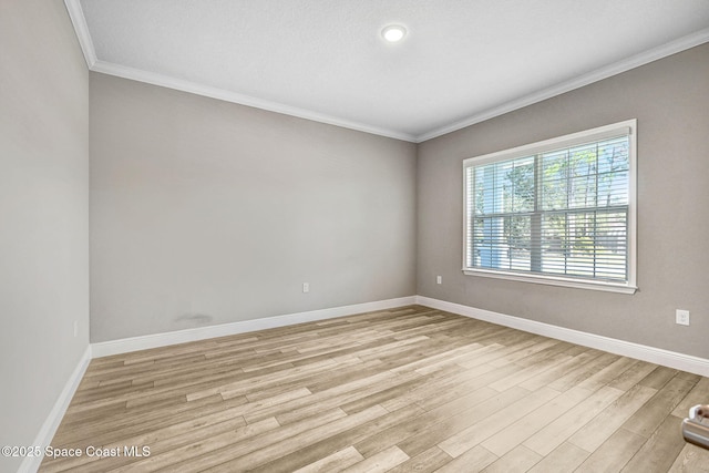 unfurnished room with crown molding and light wood-type flooring